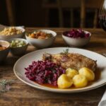 Wine to accompany the meal Roast leg of goose with quince and red cabbage and potato dumplings, served with a glass of Blaufränkisch from Burgenland