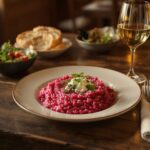 Wine with food - Beetroot risotto with horseradish and goat's cheese on a wooden table with a Pinot Gris glass