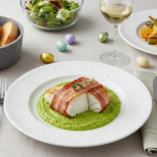 Wine with food: Cod wrapped in bacon alongside a glass of Pinot Blanc wine.